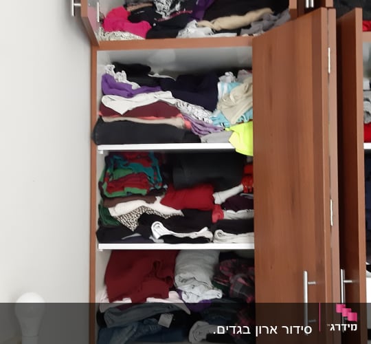 ארון בגדים פתוח עם בגדים מקופלים על מדפים